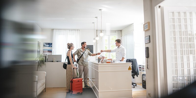 Hotelrezeption Gäste checken bei der Hotelrezeption ein