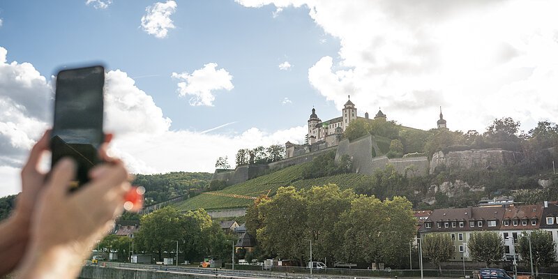 Festung Marienberg Würzburg Blick auf die Festung Marienberg in Würzburg. Frau macht mit Smartphone ein Foto.